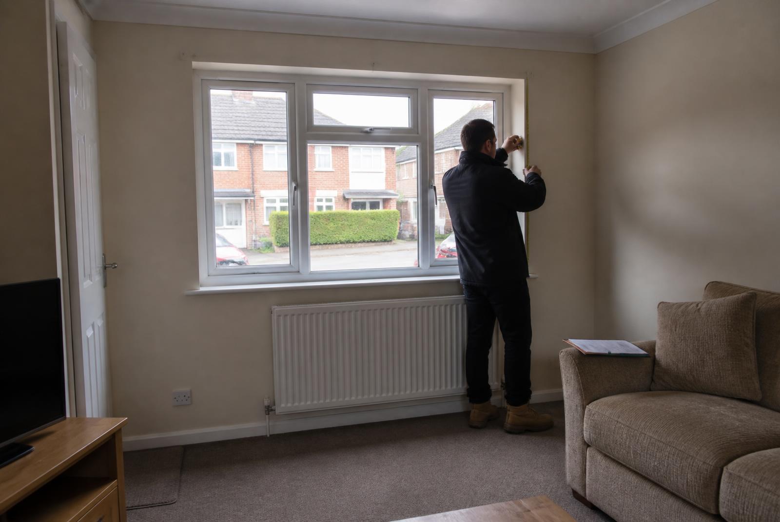 Wirral Windows surveyor measuring a living room window during a free home survey